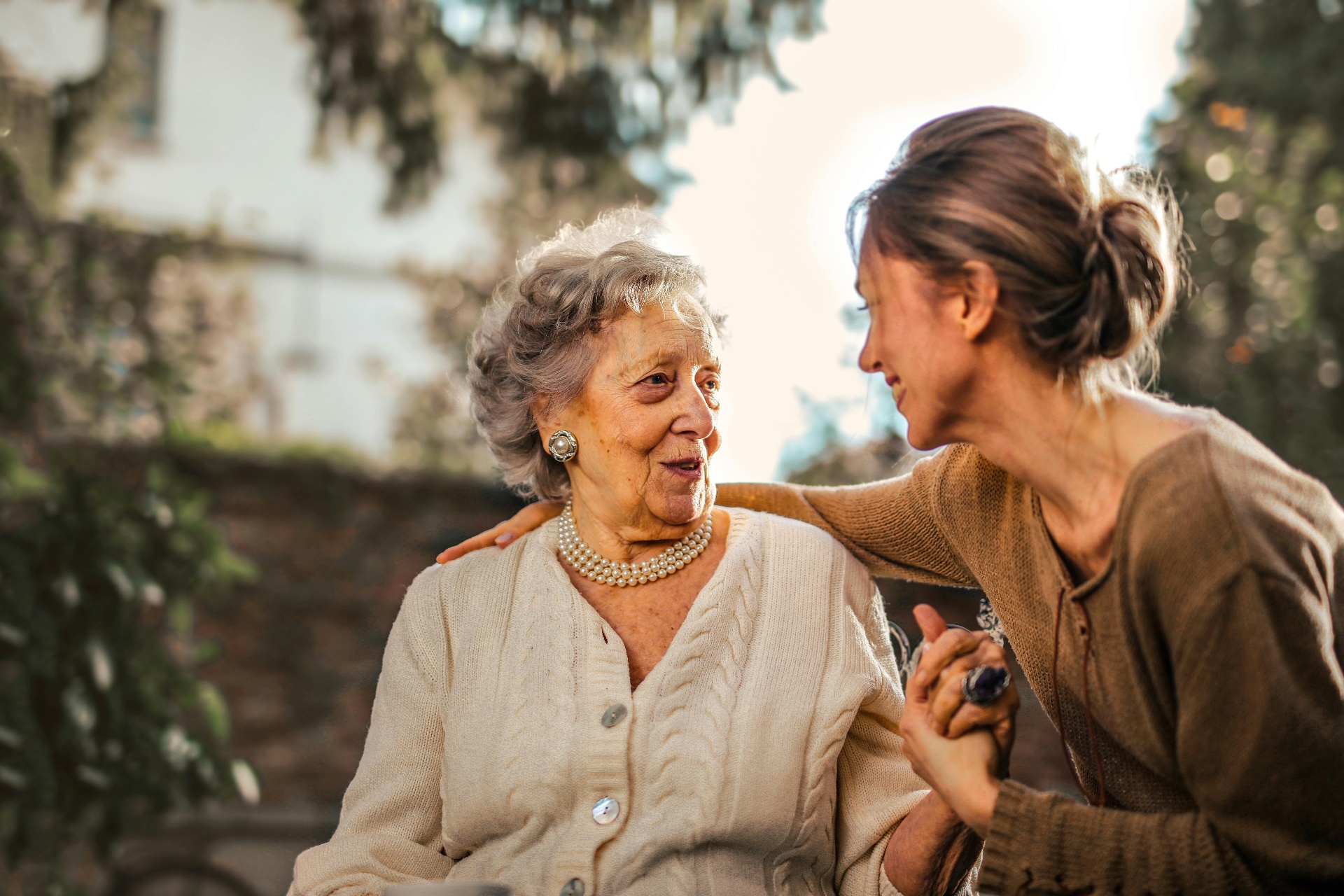 Grandmother and granddaughter sharing a meaningful conversation outdoors